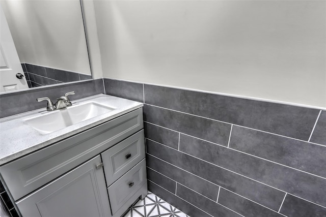 bathroom featuring vanity and tile walls