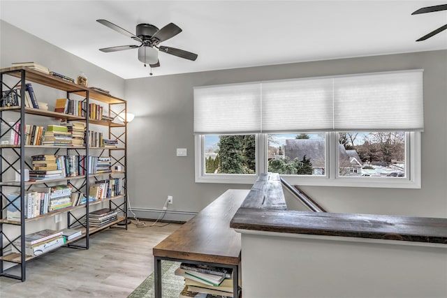 interior space with ceiling fan, baseboard heating, and light hardwood / wood-style floors