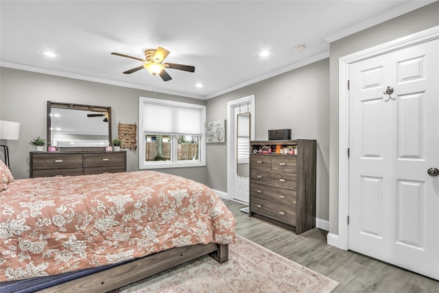 bedroom with ornamental molding, ceiling fan, and light hardwood / wood-style floors