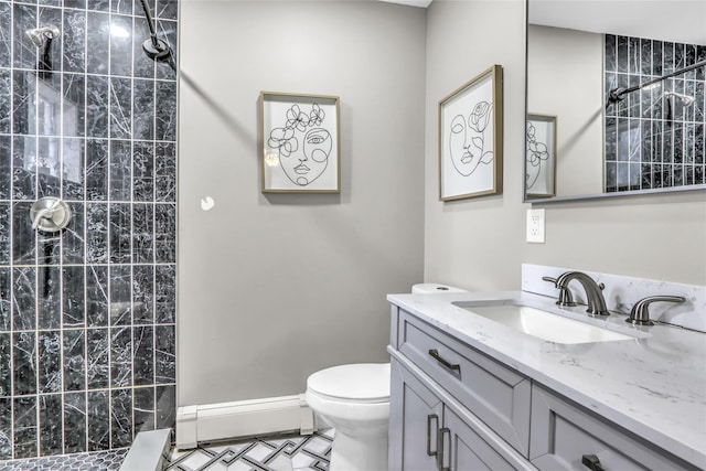 bathroom featuring vanity, toilet, and a tile shower