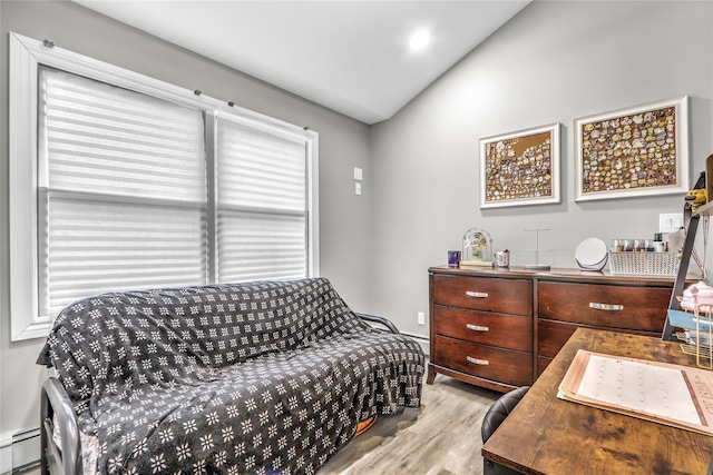 bedroom featuring vaulted ceiling, baseboard heating, and light hardwood / wood-style floors