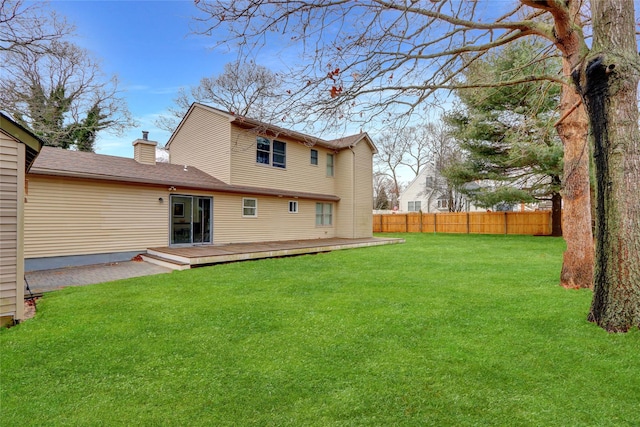 back of house with a wooden deck and a yard