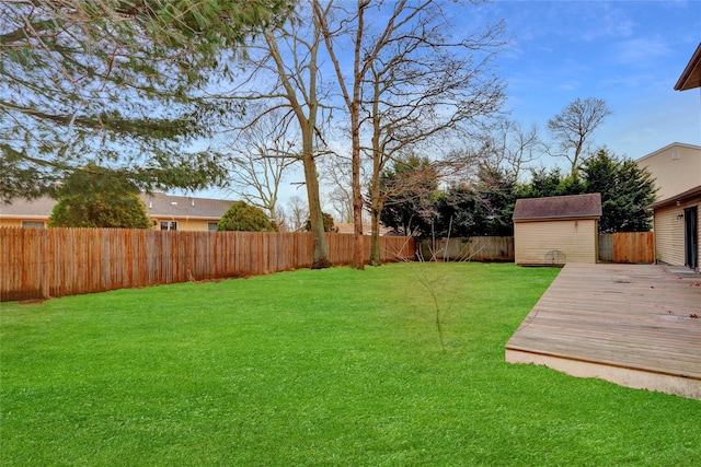 view of yard with a wooden deck and a storage unit