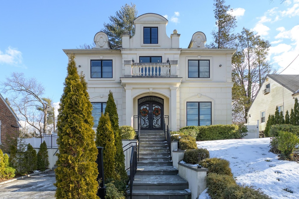 french country inspired facade featuring french doors and a balcony