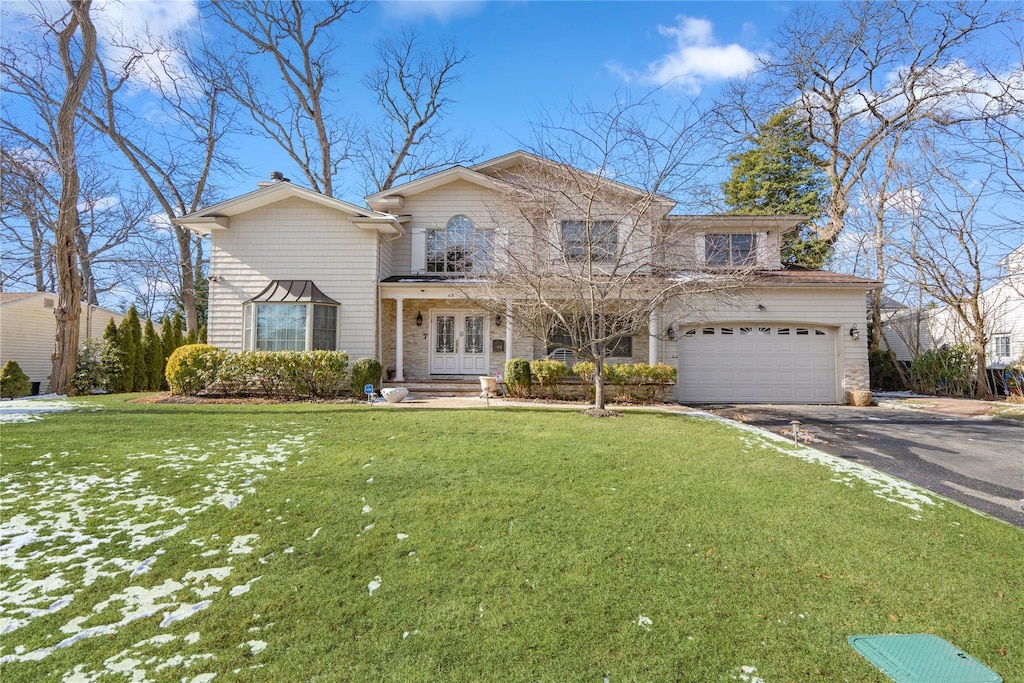 view of property with a garage and a front yard