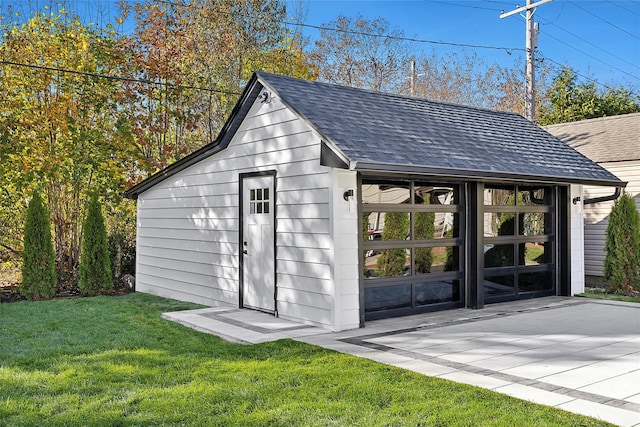 view of outdoor structure featuring a garage and a yard