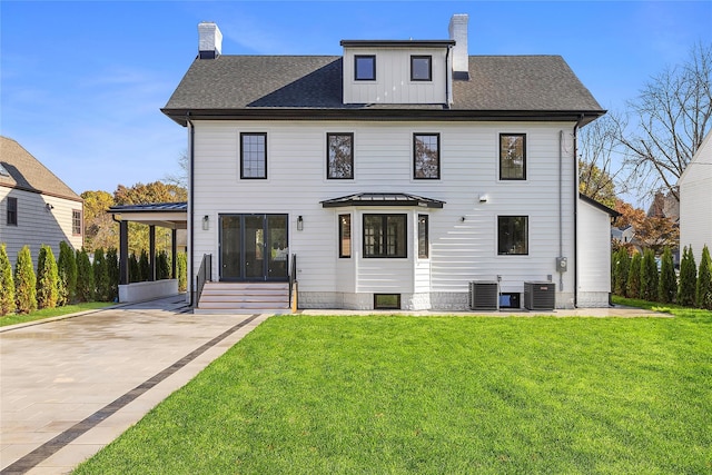 view of front facade with central AC, a chimney, and a front lawn