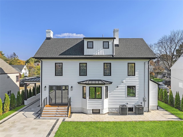 132 Arthur St, Garden City, NY 11530 - rear view of property with a chimney, a patio, a lawn, and a standing seam roof