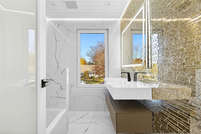 132 Arthur St, Garden City, NY 11530 - full bathroom featuring vanity, marble tiled flooring, a tub to relax in, and healthy amount of natural light