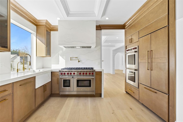 132 Arthur St, Garden City, NY 11530 - kitchen with stainless steel appliances, extractor fan, glass insert cabinets, light wood-type flooring, and crown molding