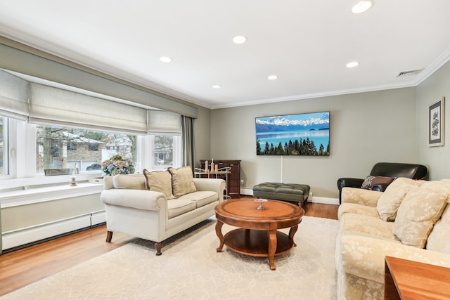 living room with baseboard heating, crown molding, and light hardwood / wood-style flooring