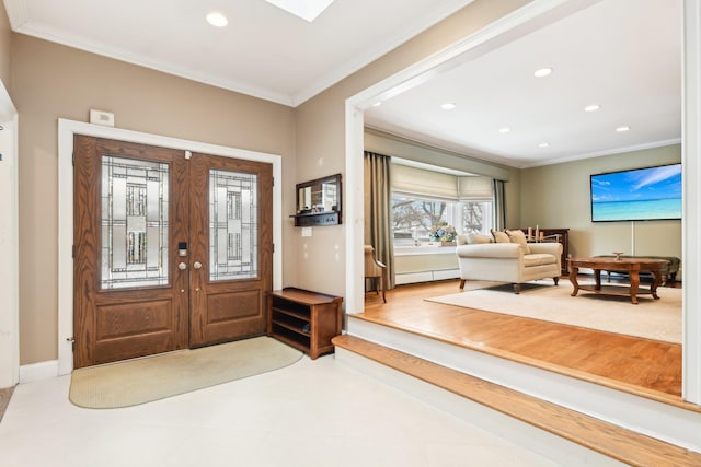 entryway with crown molding, baseboard heating, and french doors