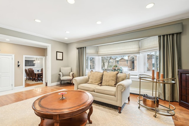 living room with ornamental molding, plenty of natural light, and light wood-type flooring