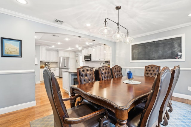 dining room featuring crown molding and light wood-type flooring