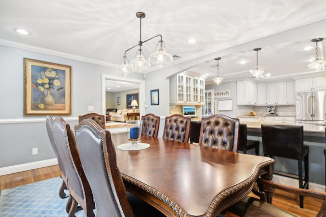 dining area featuring hardwood / wood-style flooring and crown molding