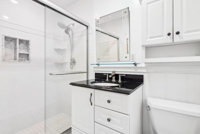 bathroom with vanity, a shower with shower door, and toilet