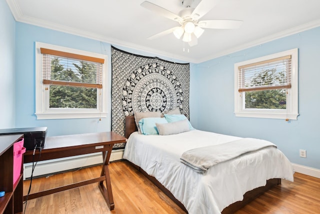 bedroom with a baseboard heating unit, crown molding, hardwood / wood-style floors, and ceiling fan