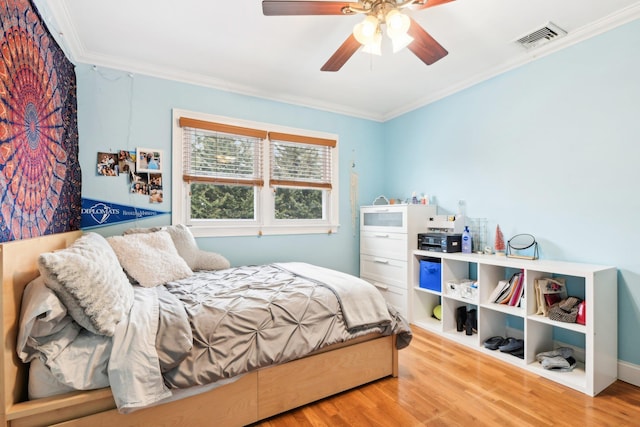 bedroom featuring ornamental molding, light hardwood / wood-style floors, and ceiling fan