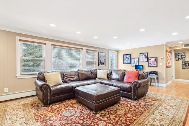 living room featuring a baseboard radiator, crown molding, and light wood-type flooring