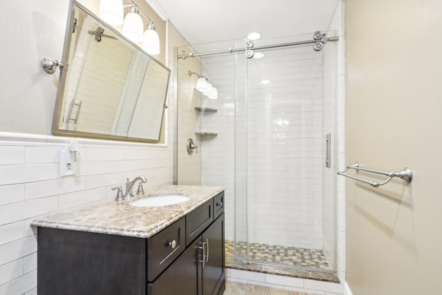 bathroom featuring vanity, tile walls, and walk in shower