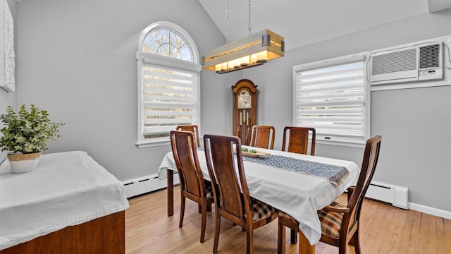 dining room with baseboard heating, lofted ceiling, and light wood-type flooring