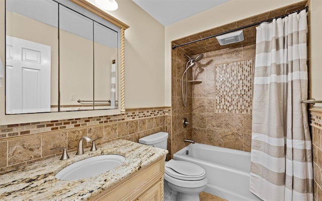 full bathroom featuring shower / tub combo, vanity, toilet, and tile walls