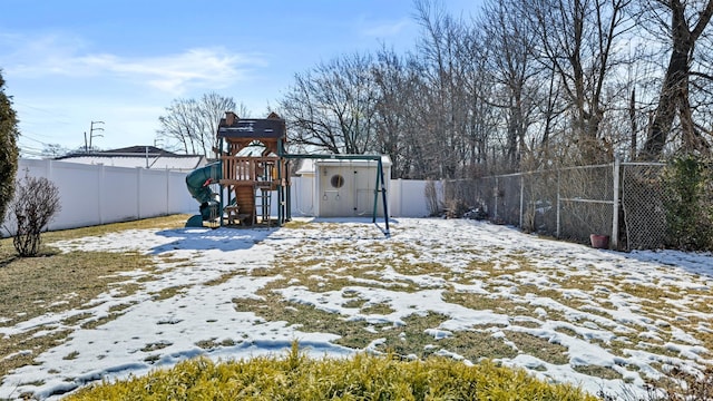 yard covered in snow featuring a playground