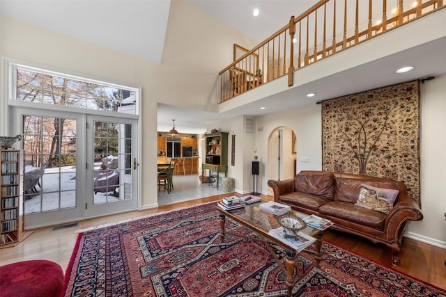 living room with a high ceiling and light wood-type flooring