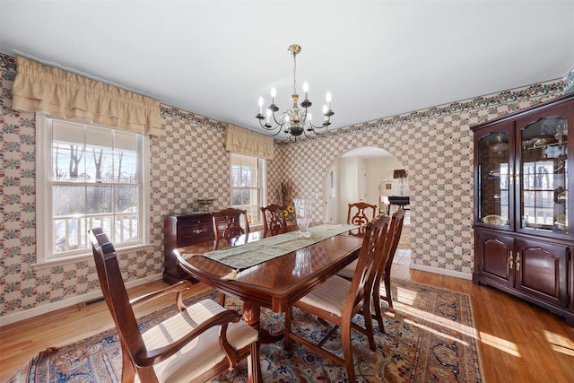 dining space with hardwood / wood-style flooring and a chandelier