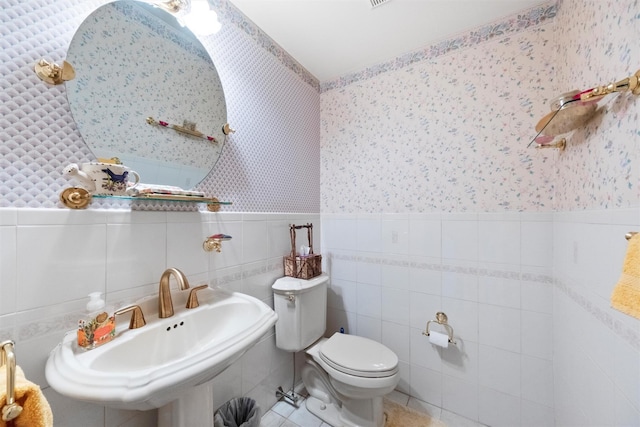 bathroom featuring tile walls, sink, tile patterned floors, and toilet