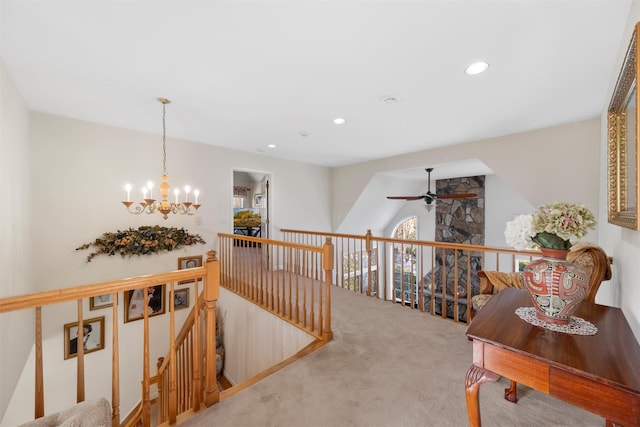 hallway featuring vaulted ceiling, carpet floors, and an inviting chandelier