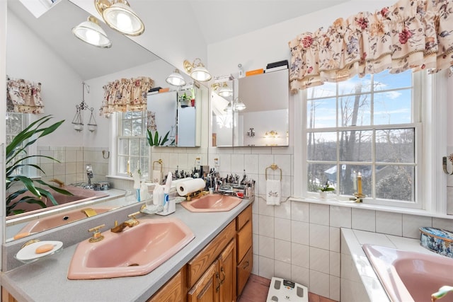 bathroom featuring lofted ceiling, vanity, a bath, and tile walls