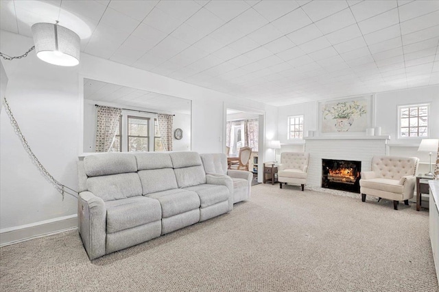 living room with a brick fireplace and carpet floors