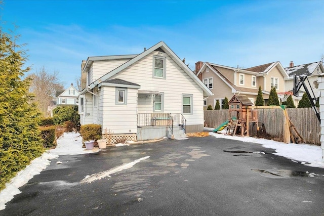 rear view of property featuring a playground