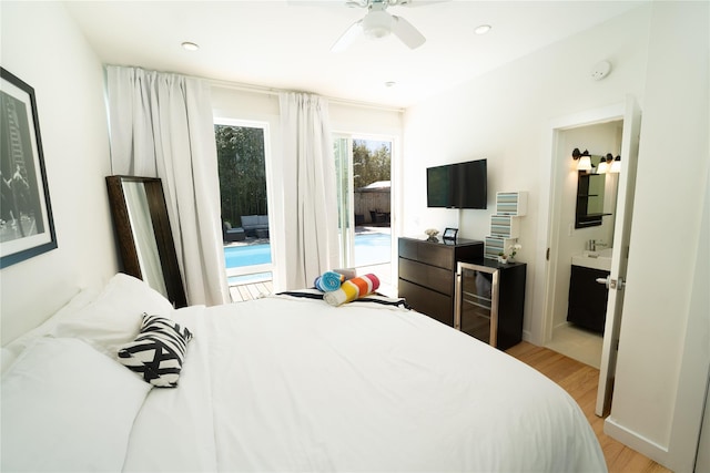 bedroom featuring ensuite bathroom, sink, light wood-type flooring, ceiling fan, and access to exterior