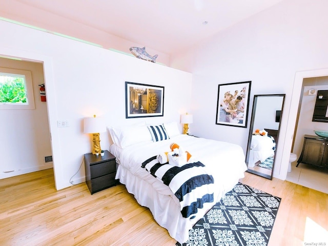 bedroom featuring light hardwood / wood-style floors and ensuite bath