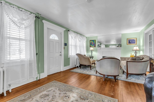 entrance foyer with hardwood / wood-style flooring, a fireplace, and radiator