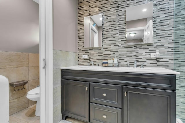 bathroom with tile patterned flooring, vanity, tile walls, and toilet