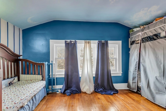 bedroom featuring lofted ceiling and wood-type flooring