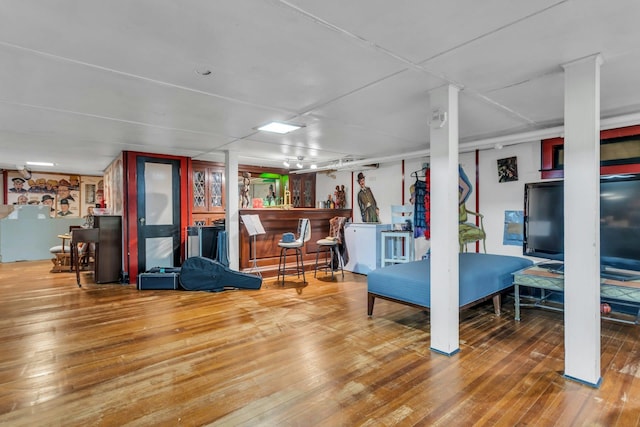 living room with bar and wood-type flooring