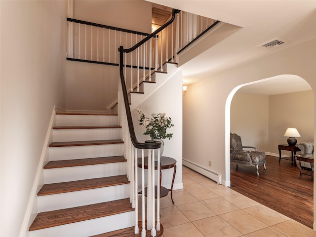 1 Regina Ct, Blauvelt, NY 10913 - stairs with baseboards, visible vents, arched walkways, and a baseboard radiator