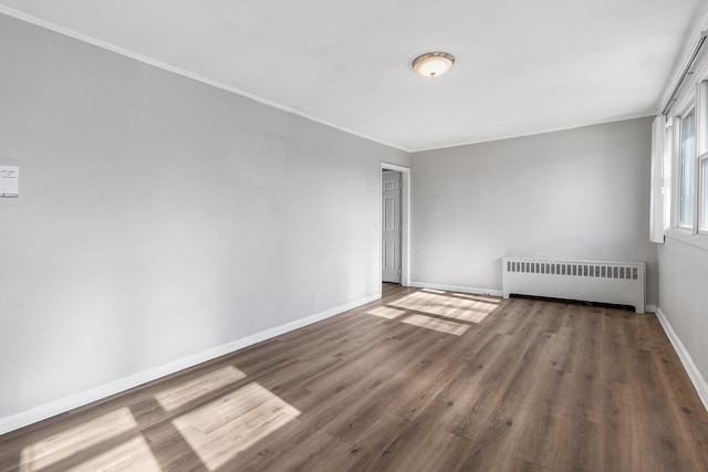 unfurnished room with radiator heating unit and dark hardwood / wood-style floors