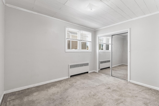 unfurnished bedroom featuring radiator, crown molding, light colored carpet, and a closet