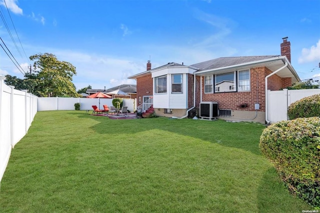 rear view of property featuring a yard, central AC unit, and a patio