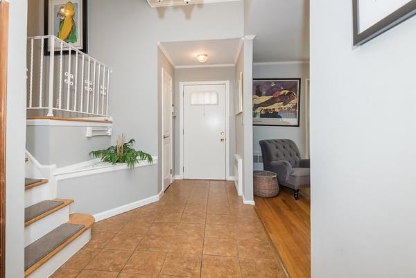 entrance foyer with ornamental molding and light tile patterned floors