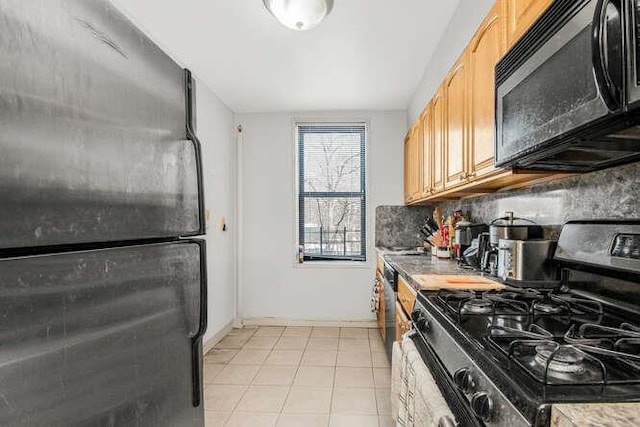 kitchen with stainless steel gas stove, tasteful backsplash, light tile patterned floors, fridge, and light brown cabinets