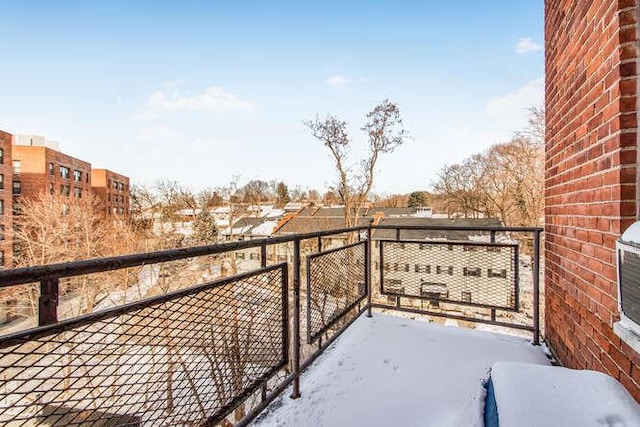 view of snow covered back of property