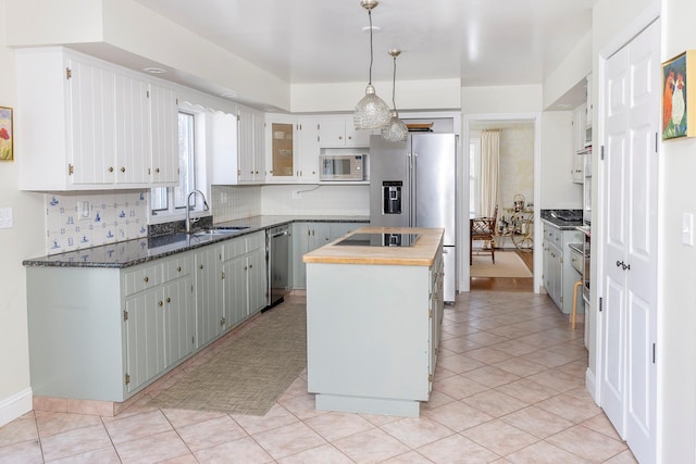 kitchen featuring sink, white cabinets, wooden counters, a center island, and stainless steel appliances