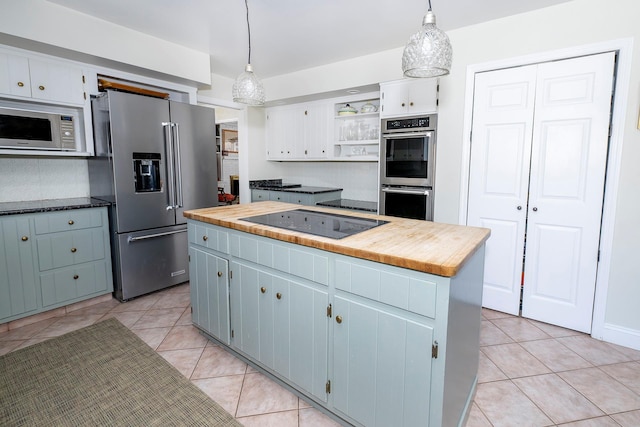 kitchen with a kitchen island, white cabinetry, appliances with stainless steel finishes, and pendant lighting