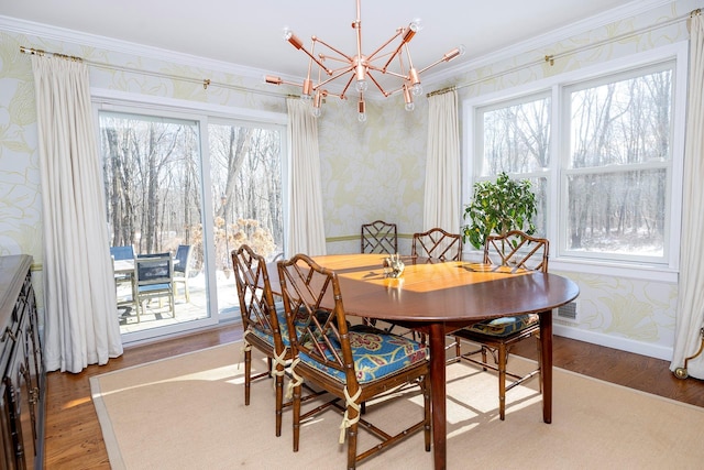 dining room featuring crown molding, a notable chandelier, and hardwood / wood-style flooring